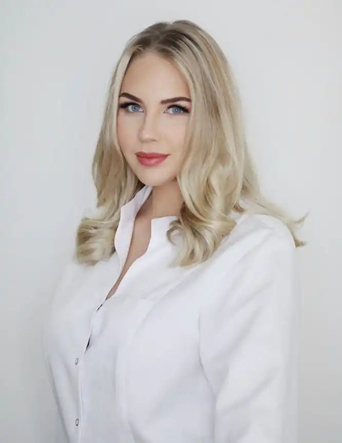 Woman with blonde hair wearing a white button-up shirt.