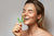 Woman laughing while holding a cannabis leaf near her face.